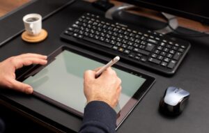 Designer Working On Digital Tablet Using Stylus Pen on Work Desk